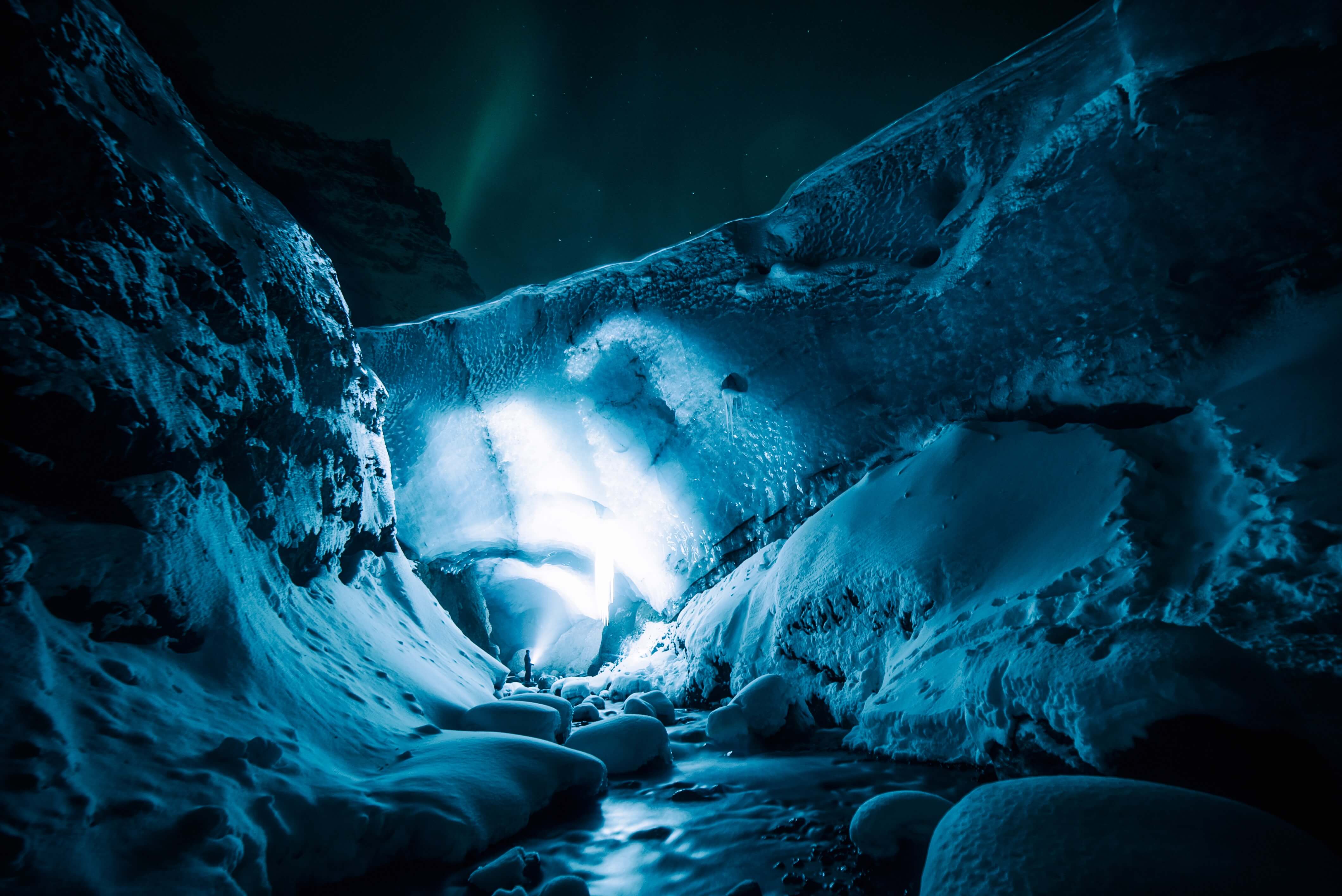 persona que enciende una linterna en un glaciar en la noche